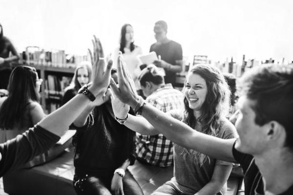 Group of youngsters slaping hands in greeting